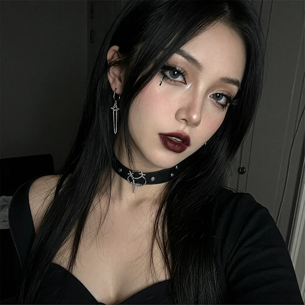 Gothic-styled woman with long black hair, dark red lipstick, studded leather choker, star earring